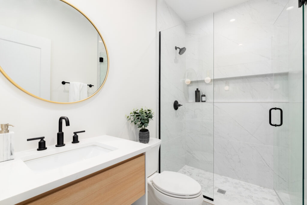 Modern renovated bathroom, glass shower, hanging vanity white walls, black shower heads