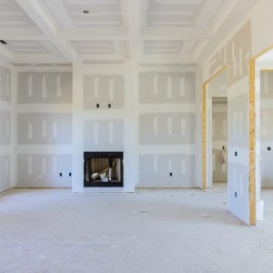 To prepare the walls of a newly constructed house to be painted, finishing putty is applied to the walls of an empty apartment