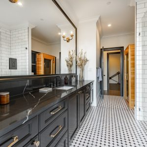 Very large bathroom with luxury decor glass wall shower free standing bathtub double sinks subway tile sauna black cabinets tiled walls built in shelving